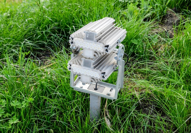 A close-up shot of a sensor node deployed in a wetland environment. The sensor is partially submerged in water and surrounded by lush vegetation. The camera focuses on the sensor's housing, which is designed to protect it from the elements.