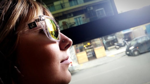 A close-up of a person with visual impairment using AI-powered glasses that recognize objects and read text aloud, set in a busy urban environment.